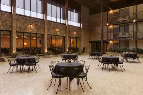 a courtyard with tables and chairs in a building at Park Inn By Radisson Sharon in West Middlesex