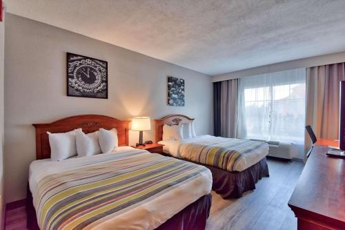 奧卡拉的住宿－Country Inn & Suites by Radisson Ocala Southwest，酒店客房设有两张床和窗户。