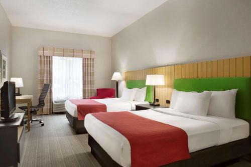 Country Inn & Suites by Radisson, Louisville East, KY في لويزفيل: غرفه فندقيه سريرين وتلفزيون