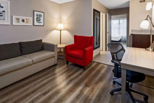 a living room with a couch and a red chair at Country Inn & Suites by Radisson, Salisbury, MD in Salisbury