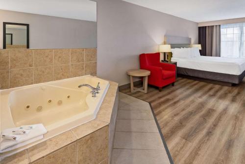 Country Inn & Suites by Radisson, Salisbury, MD في سالزبوري: غرفة في الفندق مع حوض استحمام وسرير