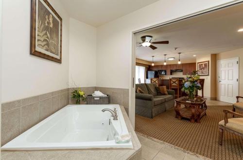 eine große weiße Badewanne im Wohnzimmer mit Sofa in der Unterkunft Jefferson Street Inn, a member of Radisson Individuals in Wausau