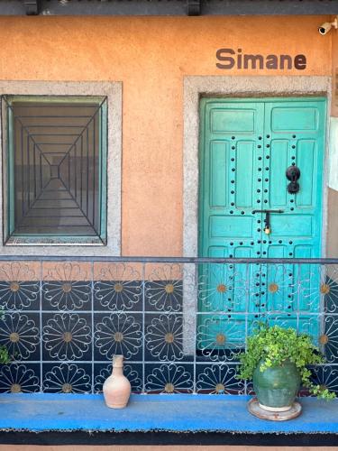 a house with a blue door and a window at Labyrinth Kasbah Dades in Aït Ben Ali