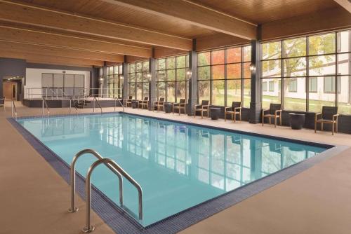 a large swimming pool in a building with windows at Oneida Hotel in Green Bay