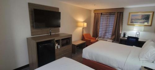 a hotel room with a bed and a flat screen tv at Best Western Kernersville in Kernersville