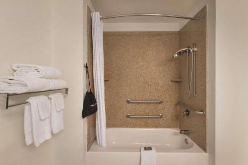 a bathroom with a shower and a bath tub with towels at Country Inn & Suites by Radisson, Madison, AL in Madison