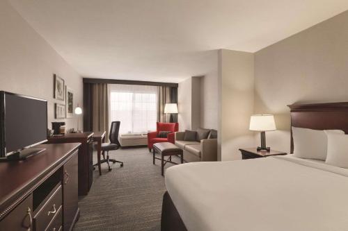 Habitación de hotel con cama y escritorio con TV. en Country Inn & Suites by Radisson, Madison, AL en Madison