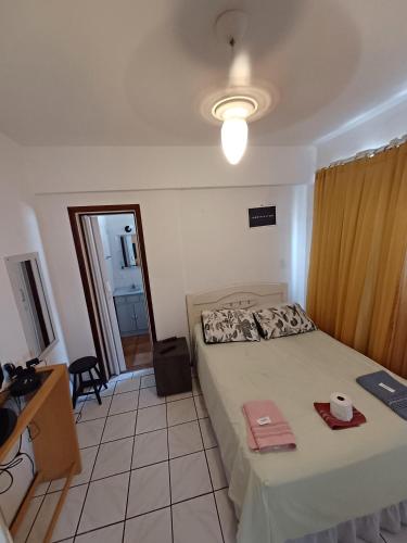 a bedroom with a bed and a desk and a window at Apto Centro Floripa 04 in Florianópolis