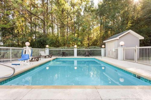 - une piscine dans une cour avec une clôture dans l'établissement Country Inn & Suites by Radisson, Tuscaloosa, AL, à Tuscaloosa