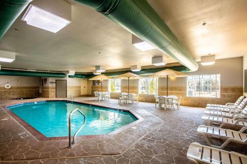 a pool in a hotel room with chairs and tables at Country Inn & Suites by Radisson, El Dorado, AR in El Dorado