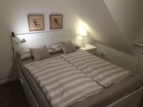 ein Schlafzimmer mit einem großen Bett und einer gestreiften Decke in der Unterkunft Am Mühlenteich 2 in Timmendorfer Strand