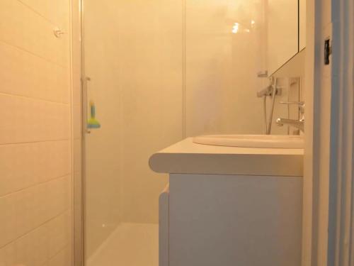 a white bathroom with a sink and a shower at West31 with beautiful sea views in Oostduinkerke