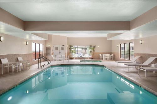 una piscina en un hotel con mesas y sillas en Country Inn & Suites by Radisson, Flagstaff, AZ en Flagstaff