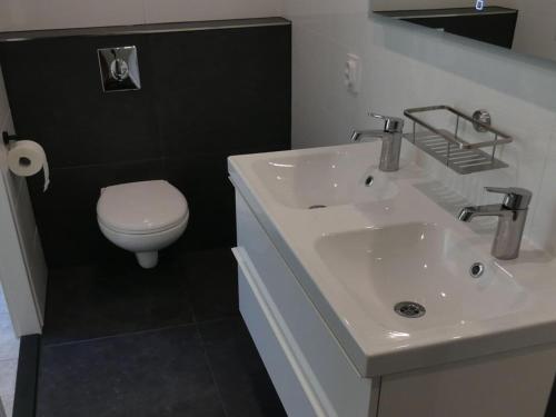 y baño con lavabo blanco y aseo. en Holiday apartment Zonnewende 16, en Sint Maartensvlotbrug