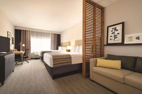 une chambre d'hôtel avec un lit et un canapé dans l'établissement Country Inn & Suites by Radisson, Page, AZ, à Page