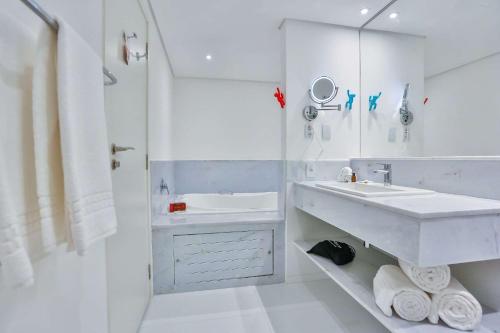 a white bathroom with a sink and a shower at Radisson RED Campinas in Campinas