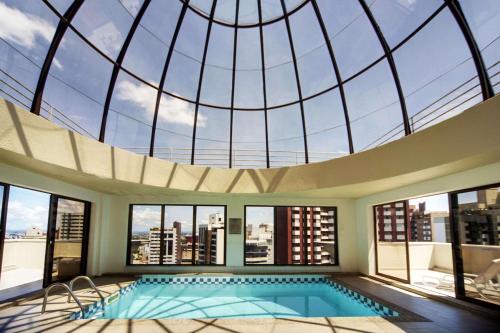 uma piscina interior com tecto abobadado em Radisson Hotel Curitiba em Curitiba