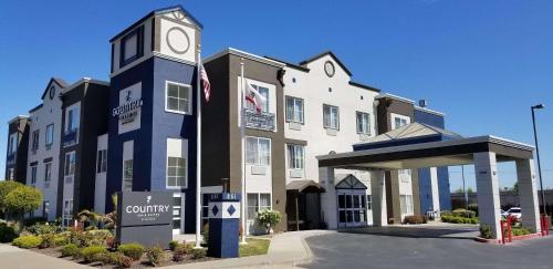 a building with a clock tower in front of it at Country Inn & Suites by Radisson, San Carlos, CA in San Carlos