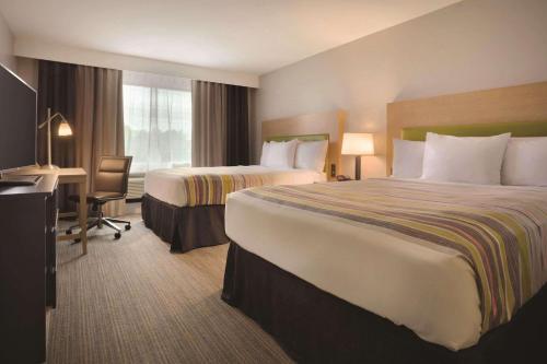 Country Inn & Suites by Radisson, Monterey Beachfront-Marina, CA tesisinde bir odada yatak veya yataklar