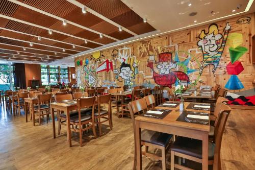 a restaurant with wooden tables and chairs and a mural at Radisson Blu São Paulo in Sao Paulo