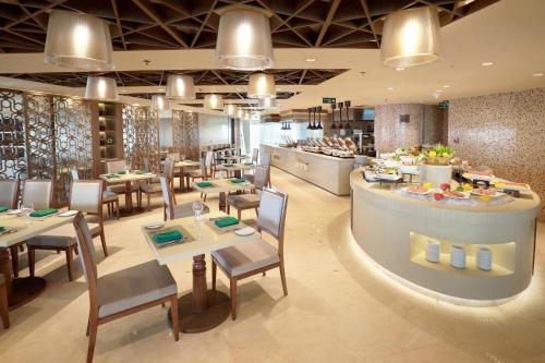 a restaurant with tables and chairs and a buffet at Crowne Plaza Dhaka Gulshan by IHG in Dhaka