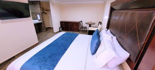 a bedroom with a large bed with a wooden headboard at Hotel Tierras Blancas in Valle de Bravo