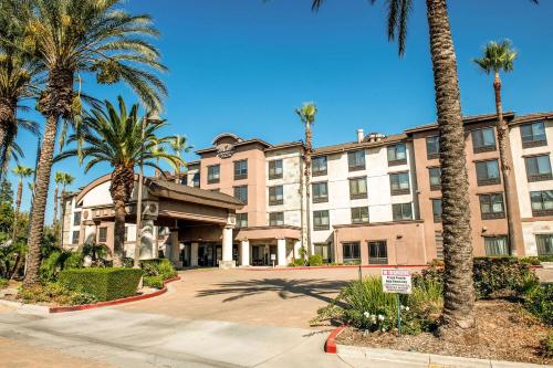 un gran edificio con palmeras delante en Country Inn & Suites by Radisson, Ontario at Ontario Mills, CA, en Ontario