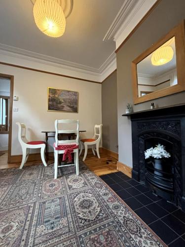 a living room with a table and a fireplace at Lovely 2BD House - 20 mins from Alexandra Palace! in London