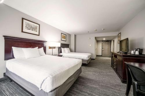 a hotel room with two beds and a desk at Country Inn & Suites by Radisson, Ontario at Ontario Mills, CA in Ontario