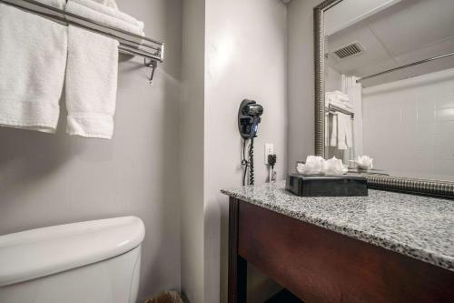 a bathroom with a toilet and a sink and a mirror at Country Inn & Suites by Radisson, Ontario at Ontario Mills, CA in Ontario