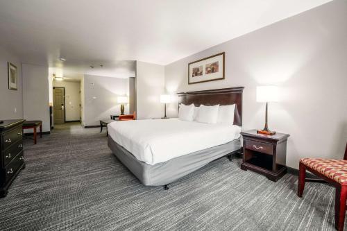 a large hotel room with a bed and a chair at Country Inn & Suites by Radisson, Ontario at Ontario Mills, CA in Ontario