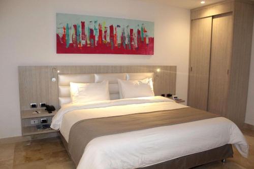 een slaapkamer met een groot bed en een schilderij aan de muur bij Radisson Diamond Barranquilla in Barranquilla