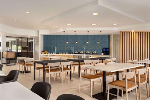 サニーベールにあるRadisson Hotel Sunnyvale - Silicon Valleyのテーブルと椅子のあるレストラン、キッチンが備わります。