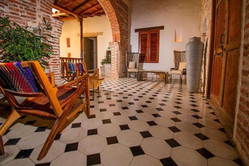 a room with rocking chairs and a tiled floor at Hotel Casa La Factoria by Faranda Boutique, a member of Radisson Individuals in Cartagena de Indias