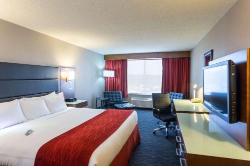 um quarto de hotel com uma cama e uma televisão de ecrã plano em Radisson Hotel & Suites Fort McMurray em Fort McMurray