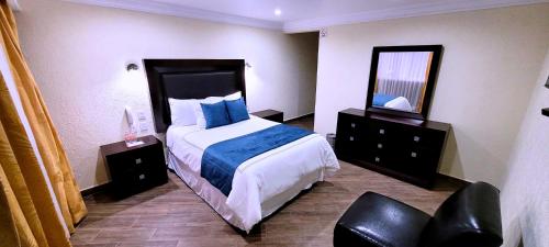 a hotel room with a bed and a mirror at Hotel Tierras Blancas in Valle de Bravo