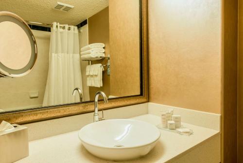y baño con lavabo blanco y espejo. en Radisson Hotel & Suites Fort McMurray, en Fort McMurray