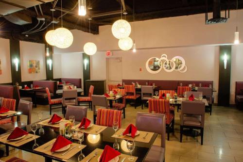 サドバリーにあるRadisson Hotel Sudburyのテーブルと椅子と赤いナプキンを用意したレストラン