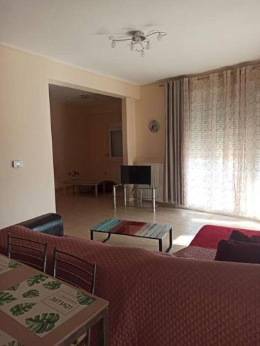 een woonkamer met een bank en een tafel bij Λαμπερό αστέρι 2 in Volos