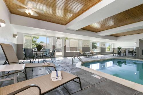 a hotel with a pool and tables and chairs at Country Inn & Suites by Radisson, Greeley, CO in Greeley