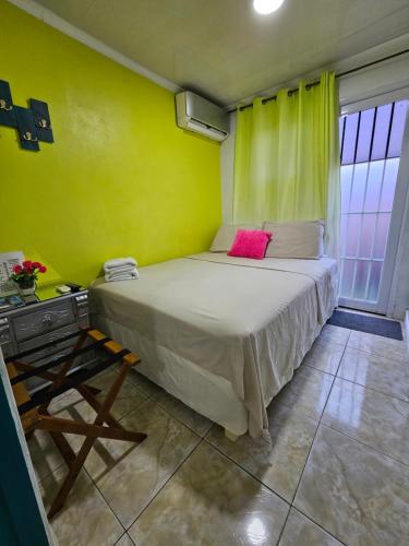 Dormitorio con cama con almohada rosa en The Jazmine's Apartment, en Oranjestad