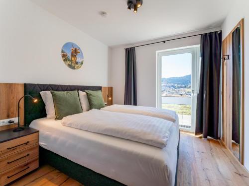 um quarto com uma cama grande e uma janela grande em Grebenzen Lodge Prinz em Sankt Lambrecht