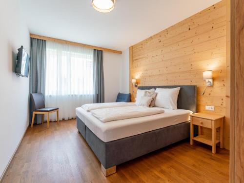 a bedroom with a large bed with a wooden wall at Pabstin in Sankt Lambrecht