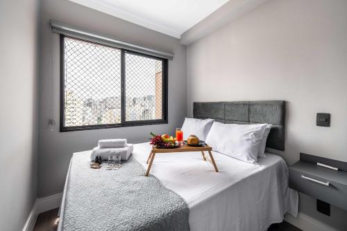a bedroom with a bed with a table on it at AA1614 Apto um Dormitório Próximo à Paulista in Sao Paulo