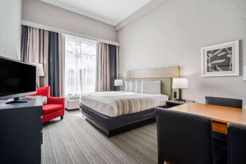 a hotel room with a bed and a desk at Country Inn & Suites by Radisson, Port Canaveral, FL in Cape Canaveral