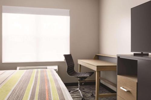 a bedroom with a bed and a desk and a window at Country Inn & Suites by Radisson, Panama City, FL in Panama City