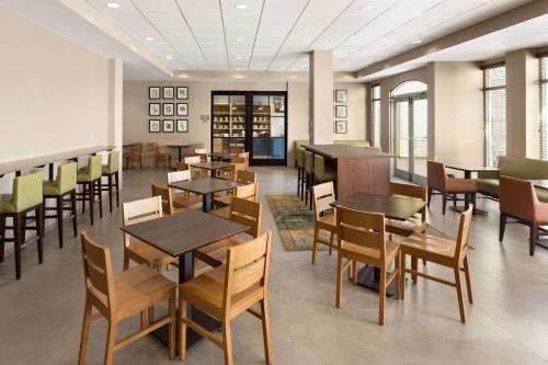 a dining room with tables and chairs and a library at Country Inn & Suites by Radisson, Port Canaveral, FL in Cape Canaveral