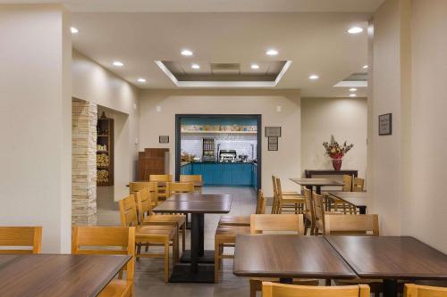 a restaurant with tables and chairs and a counter at Country Inn & Suites by Radisson, St Petersburg - Clearwater, FL in Pinellas Park