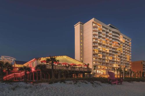 un grande hotel sulla spiaggia di notte di Radisson Panama City Beach - Oceanfront a Panama City Beach