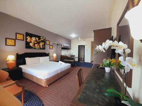 a hotel room with a bed and a desk and a room at Rainbow paradise beach front in Tanjung Bungah